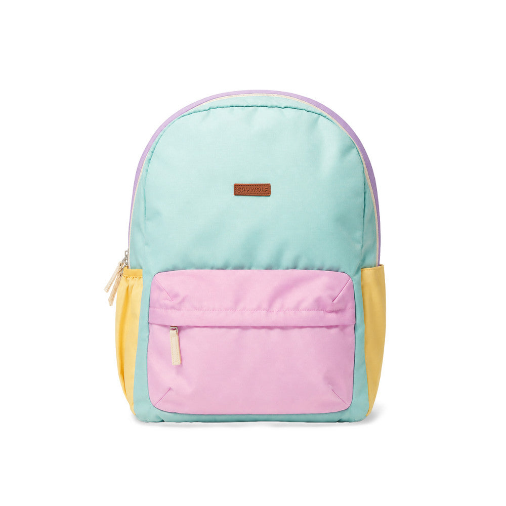 A color-blocked backpack with a mint green top, a pink front pocket, yellow side pockets, and a purple top trim, shown on a white background.