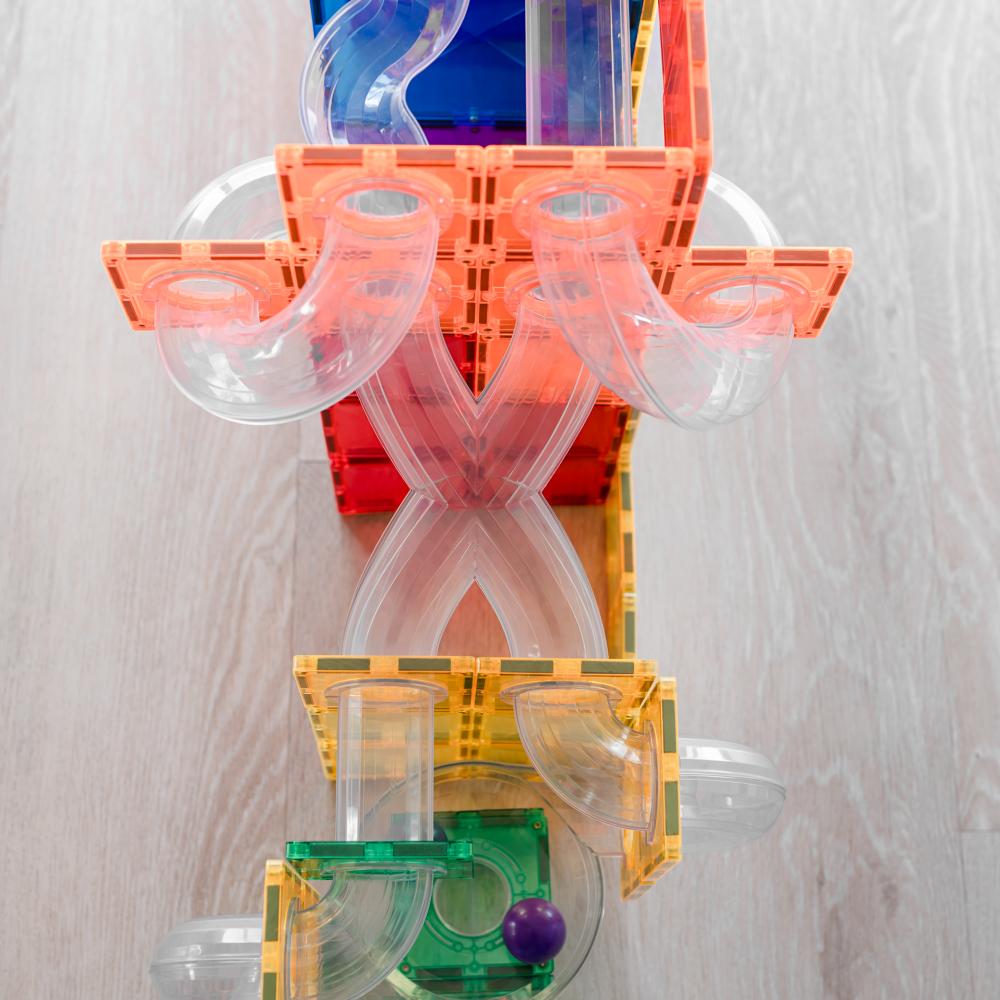 Colorful transparent plastic ball run with various shapes on a light wooden surface