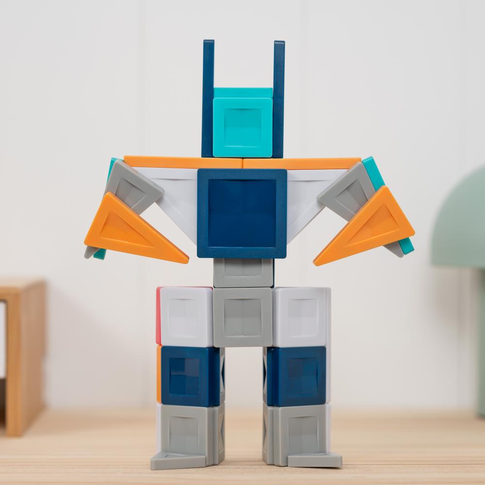 Toy robot made of Connetix interlocking blocks on a wooden surface with a light gray background