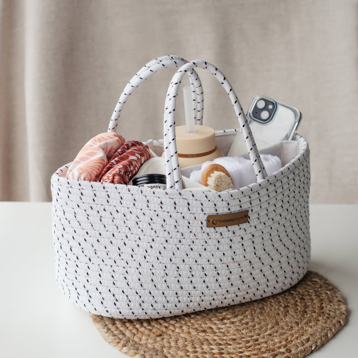 white and black nappy caddy filled with items 