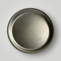 A round stainless steel plate viewed from directly above on a light gray background, with the brand name 'ease.baby' subtly embossed near the bottom right.