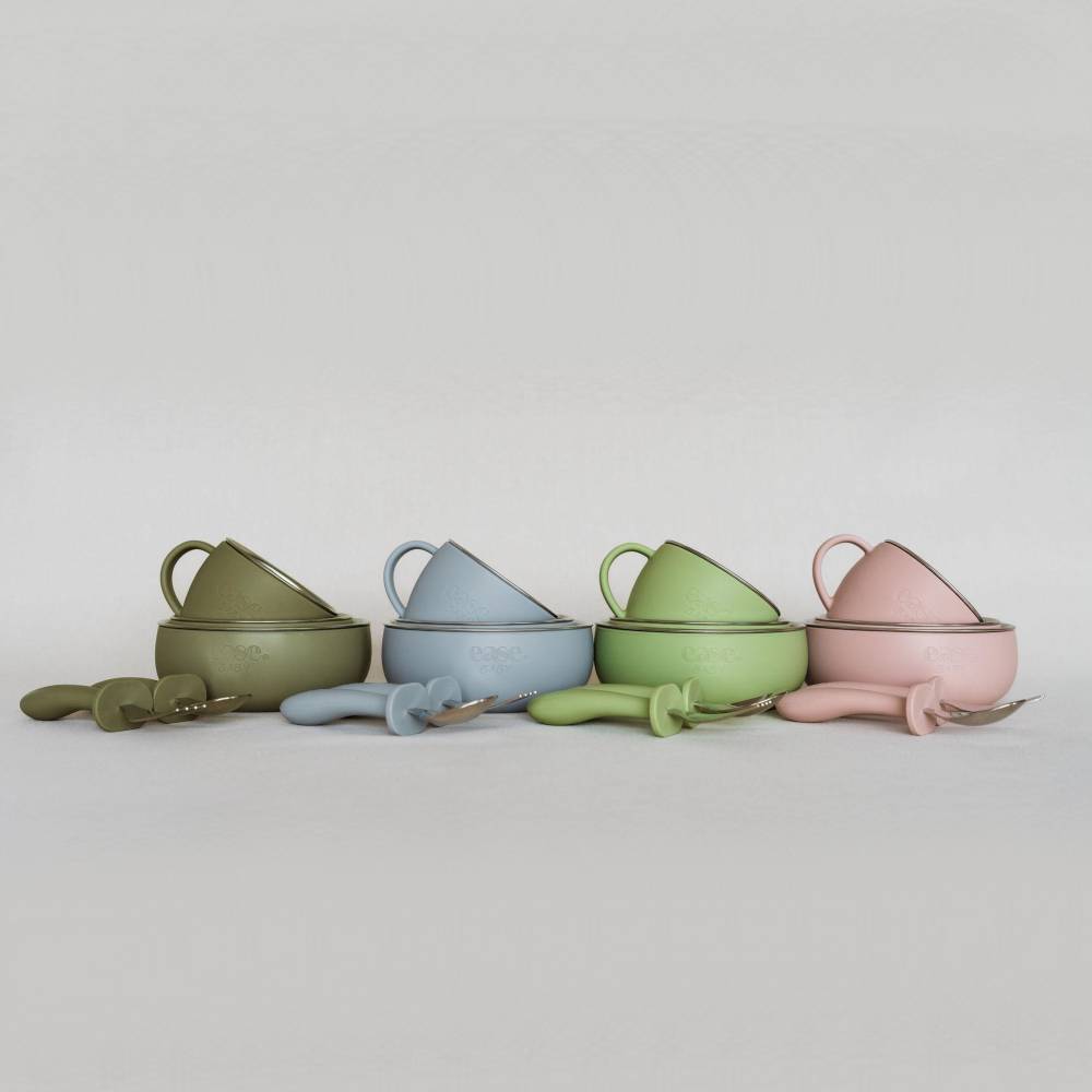 Four pastel-colored ceramic bowls with matching lids and spoons, arranged in a row on a light gray background. The bowls are olive green, light blue, light green, and light pink.