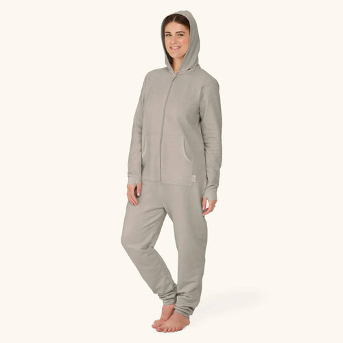 Person wearing a gray onesie on a white background