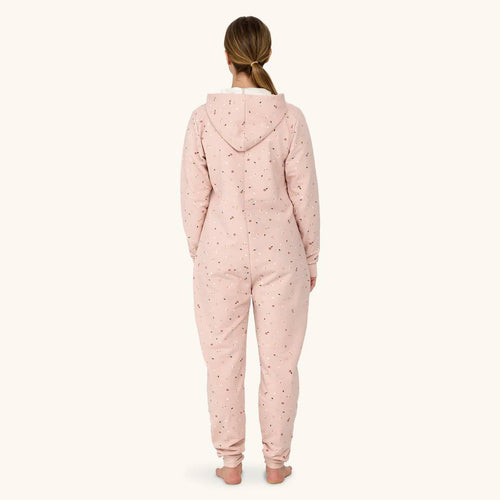 Person wearing a pink onesie with a pattern on a white background