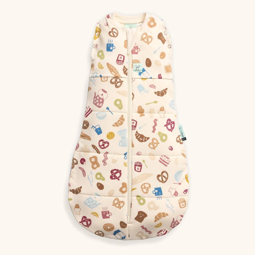 Cream baby sleeping bag with food patterns on a white background