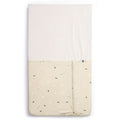 HugMe Blanket in Daisy Sprinkle pattern on a mattress on white background