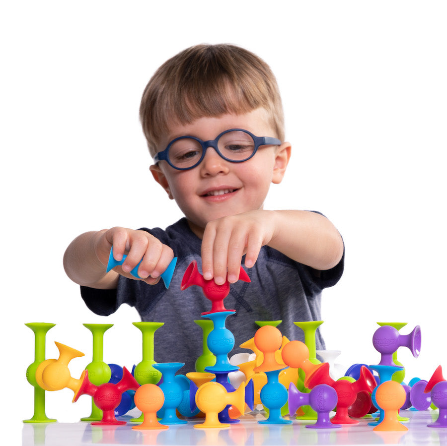 A child playing with Squigz Starter Set.