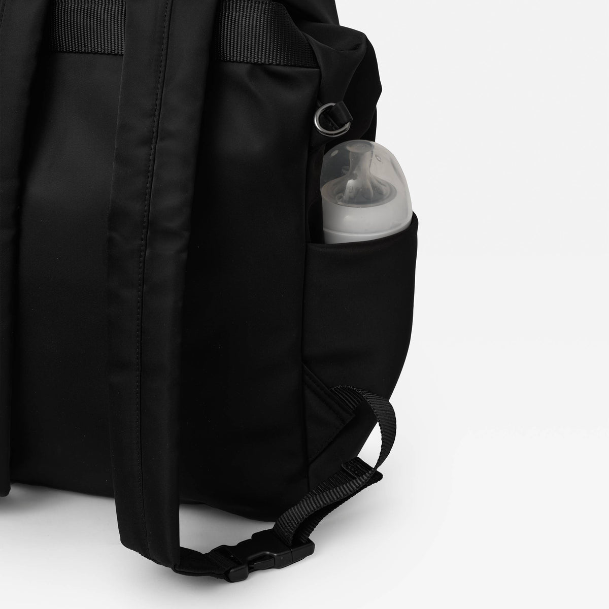 Black Finnson nappy backpack with a baby bottle in a pocket on a white background