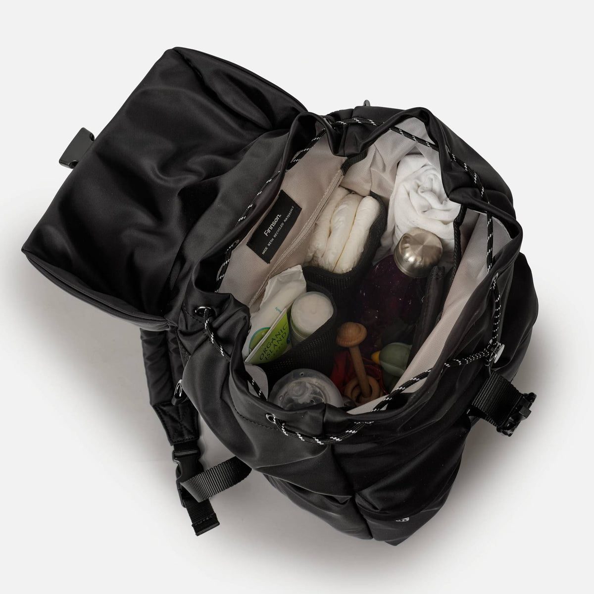 Black nappy backpack with contents inside including chnage pad  on a white background