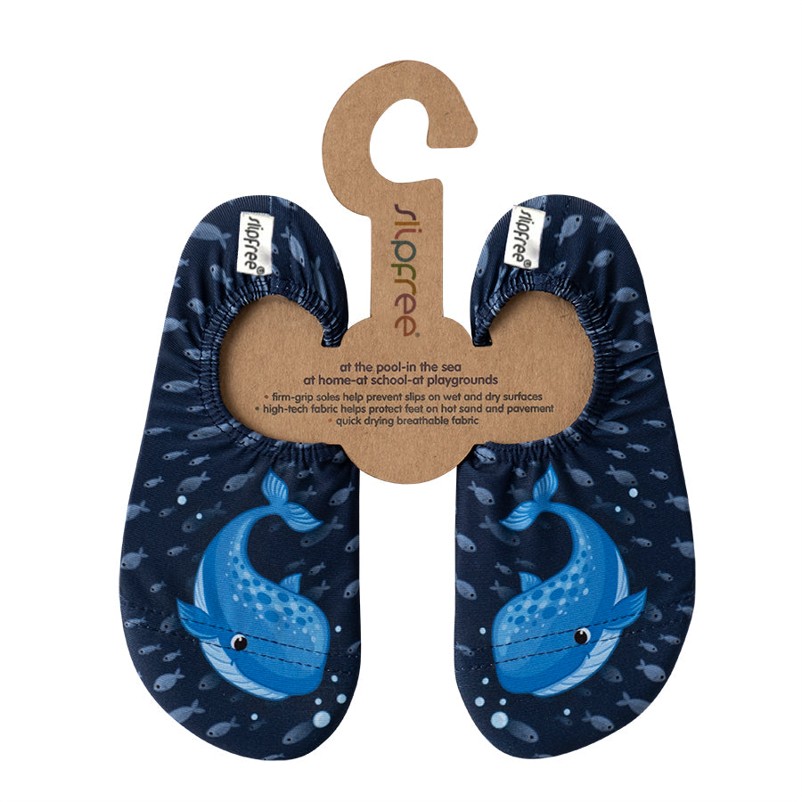 Pair of navy blue slipfree water shoes with whale design on a cardboard hanger, featuring 'slipfree' branding.
