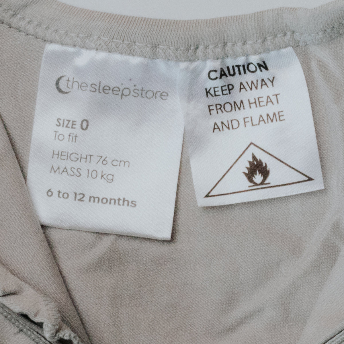 Fabric with labels indicating size, height, mass, and a cautionary label about heat and flame.