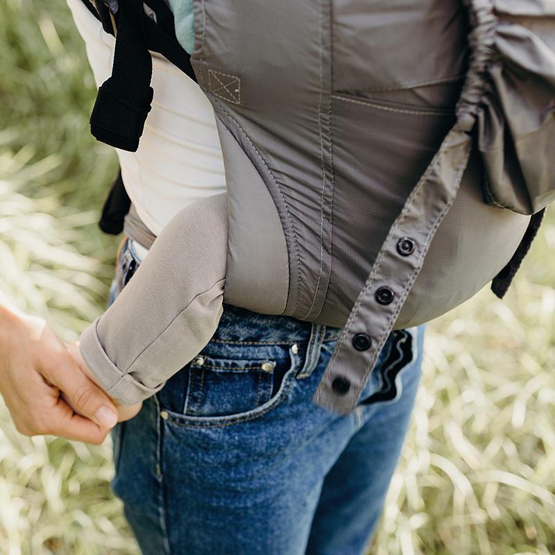 Person wearing a baby carrier in an outdoor setting