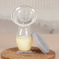 manual breastpump with milk inside and cap on the side 