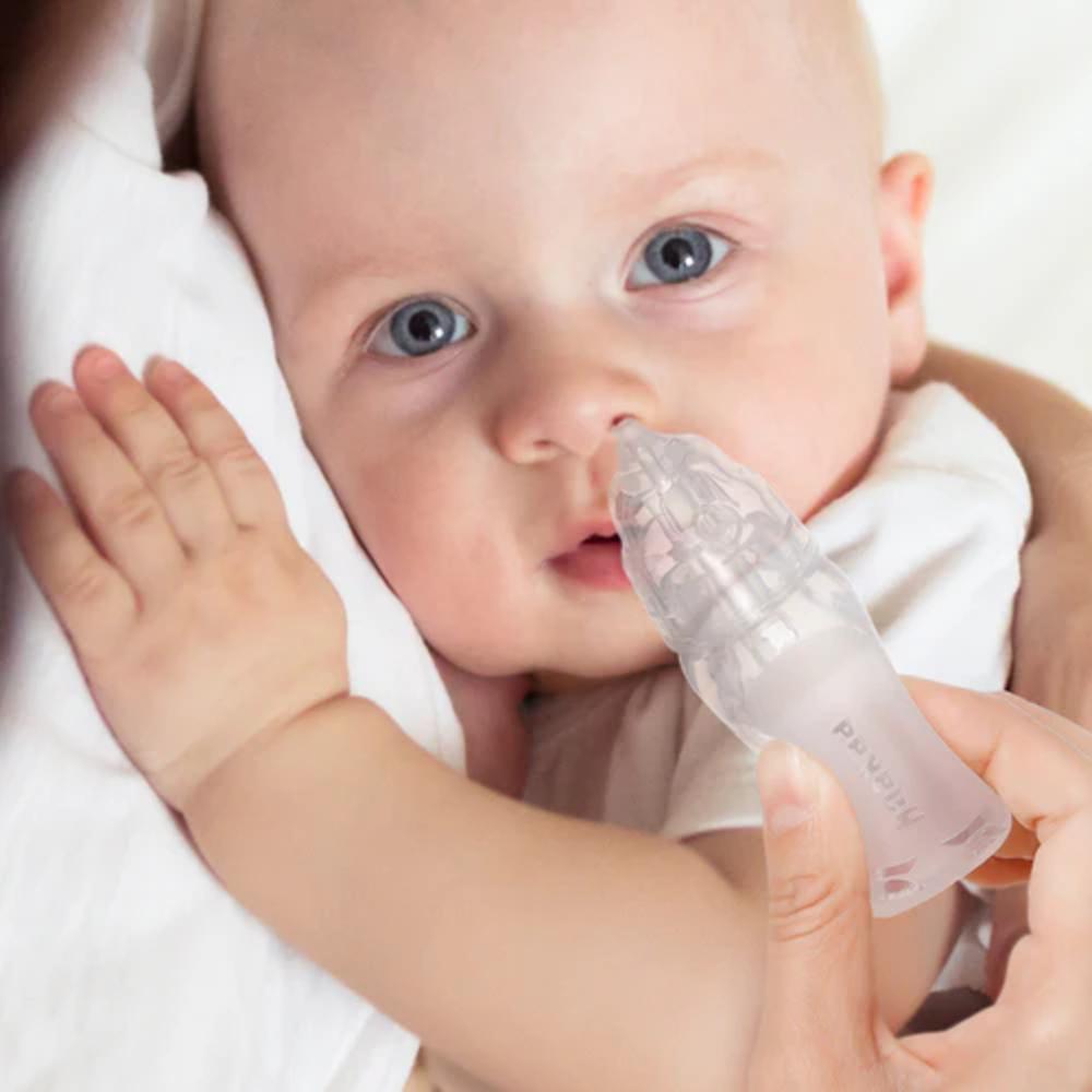 baby with penguin nail aspirator being held by adult 