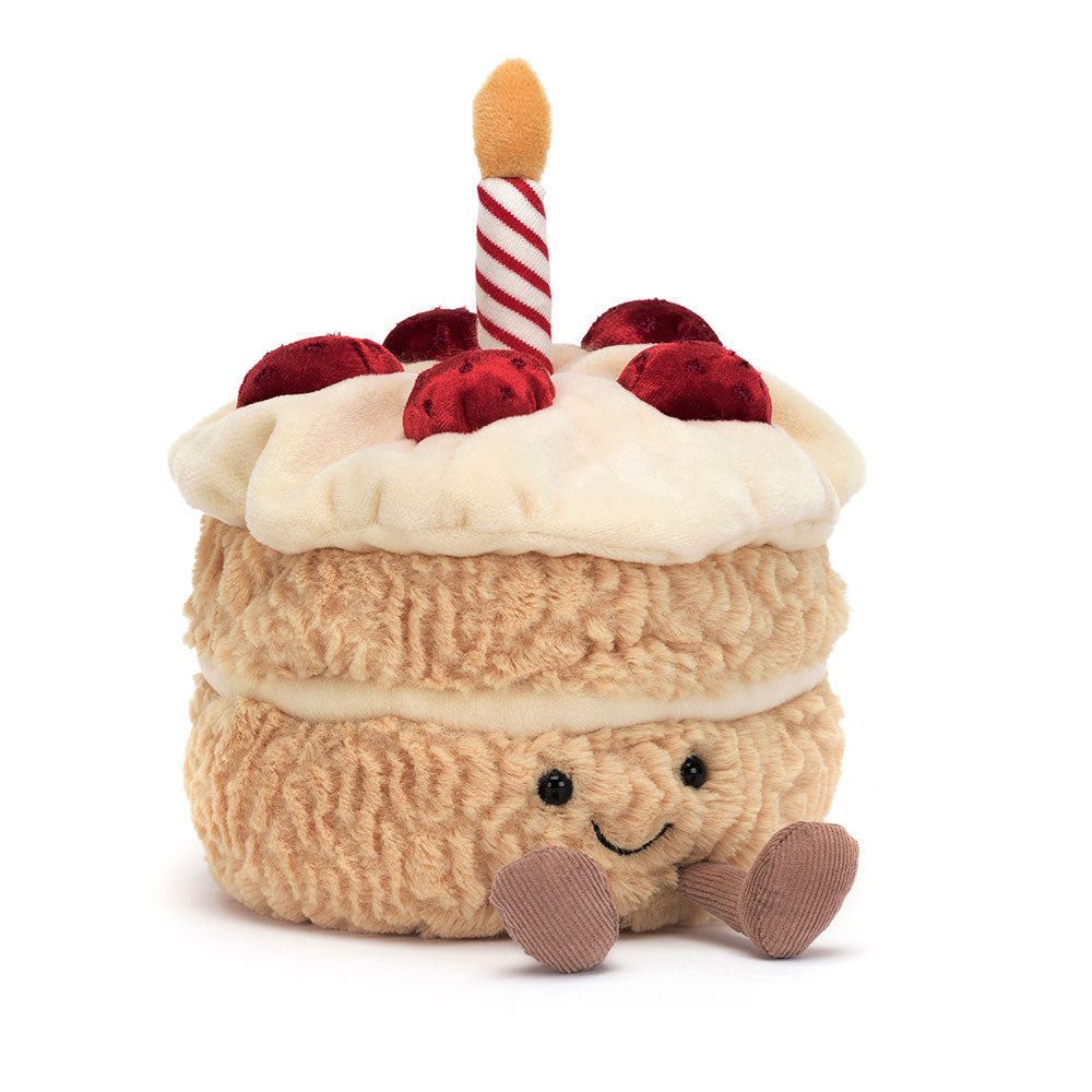 Cream colored Jellycat birthday cake soft toy against white background.