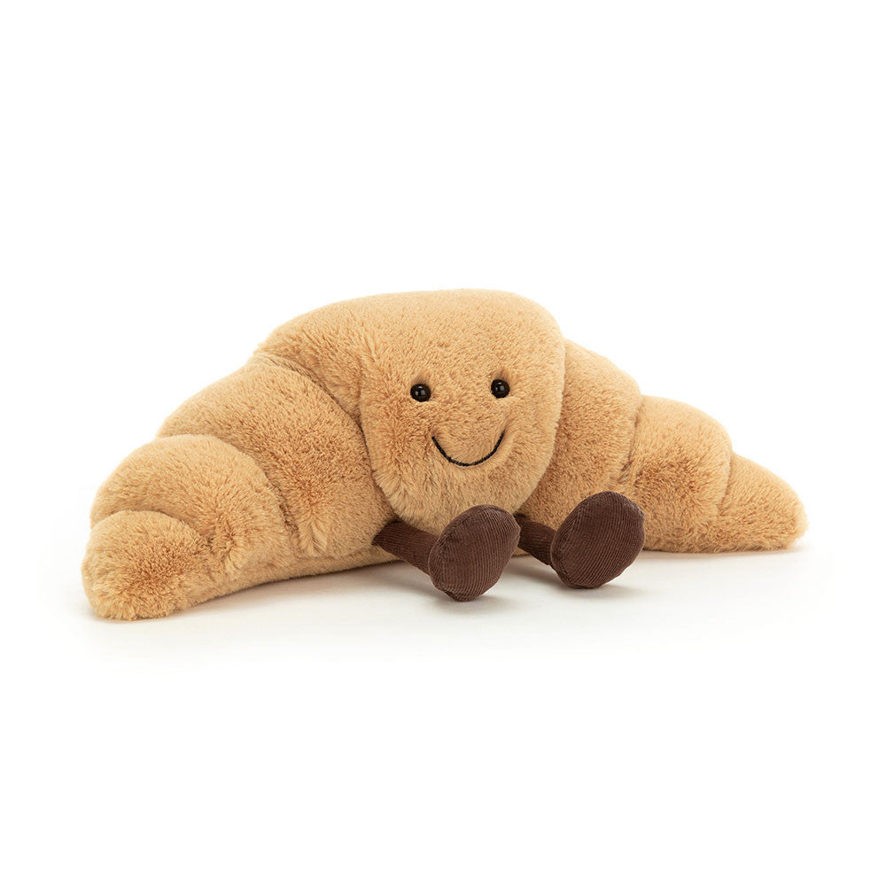 Brown Jellycat croissant soft toy against white background.