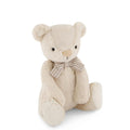 Beige Jamie Kay bear soft toy with bow against white background.