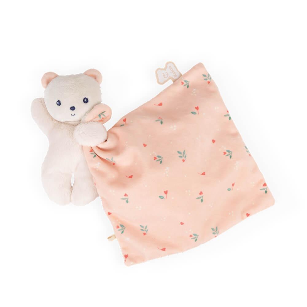 Baby pink Kaloo bear comforter against white background.