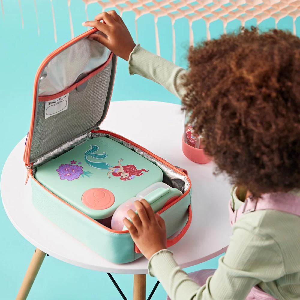 Child opening a colorful insulated lunch bag with Ariel mermaid design on a turquoise background
