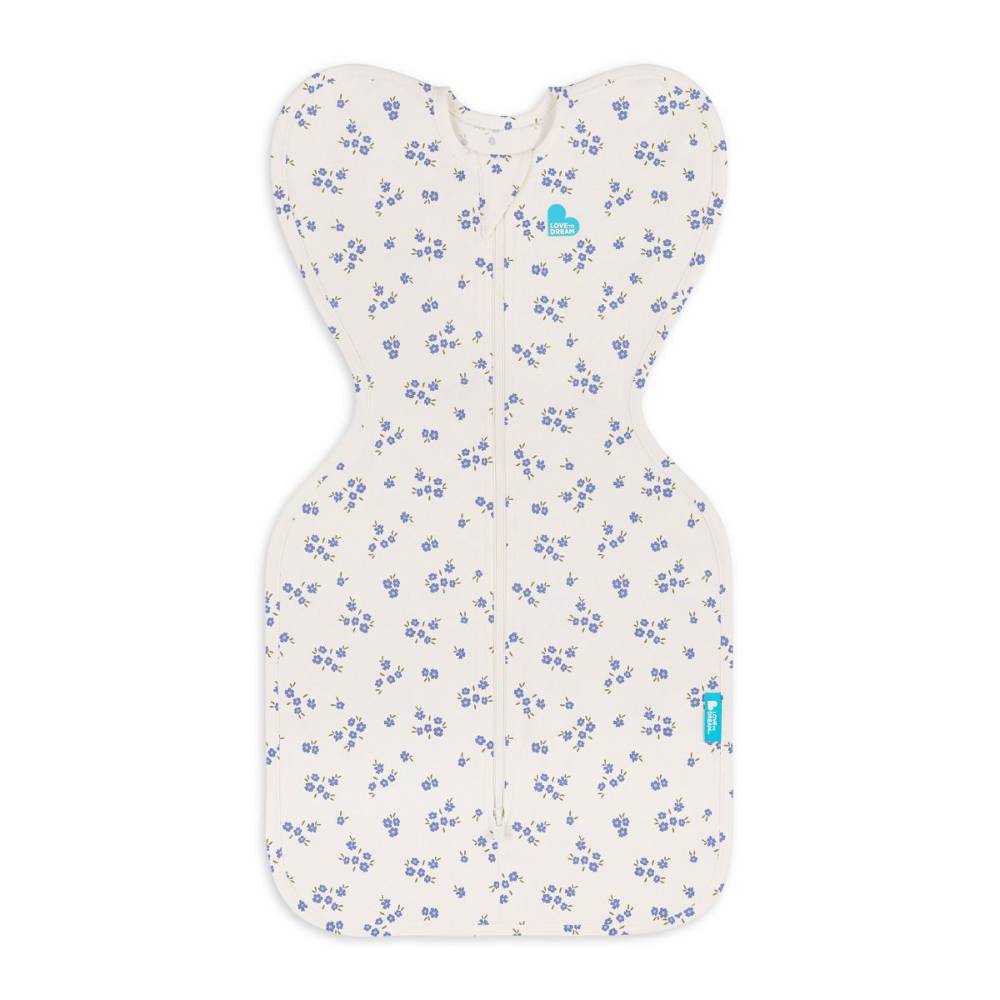 A baby sleep sack with an off-white background and a delicate blue floral pattern, featuring a front zipper and a small blue brand tag.