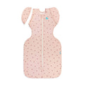 A pink transition fitted swaddle with an all over cherries print on a white background. 