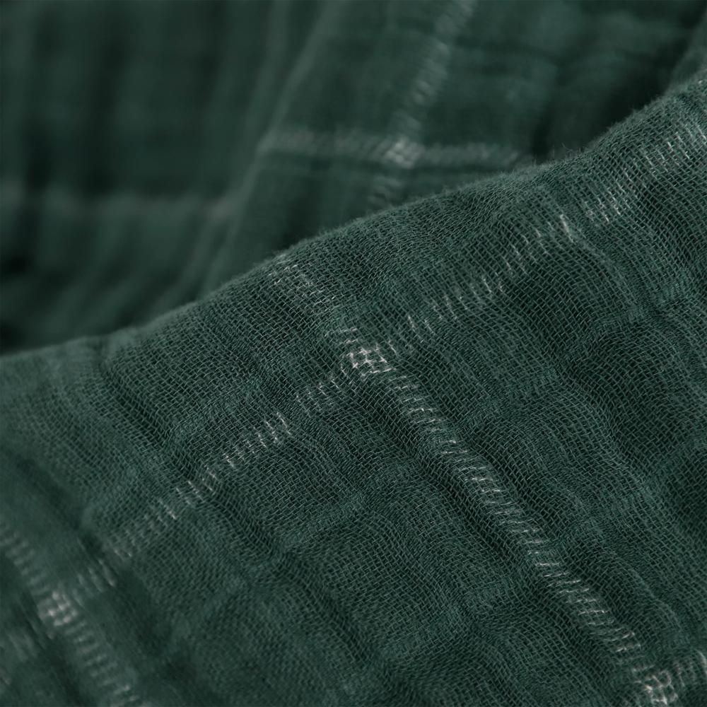 Close-up of textured muslin dark green organic cotton muslin fabric