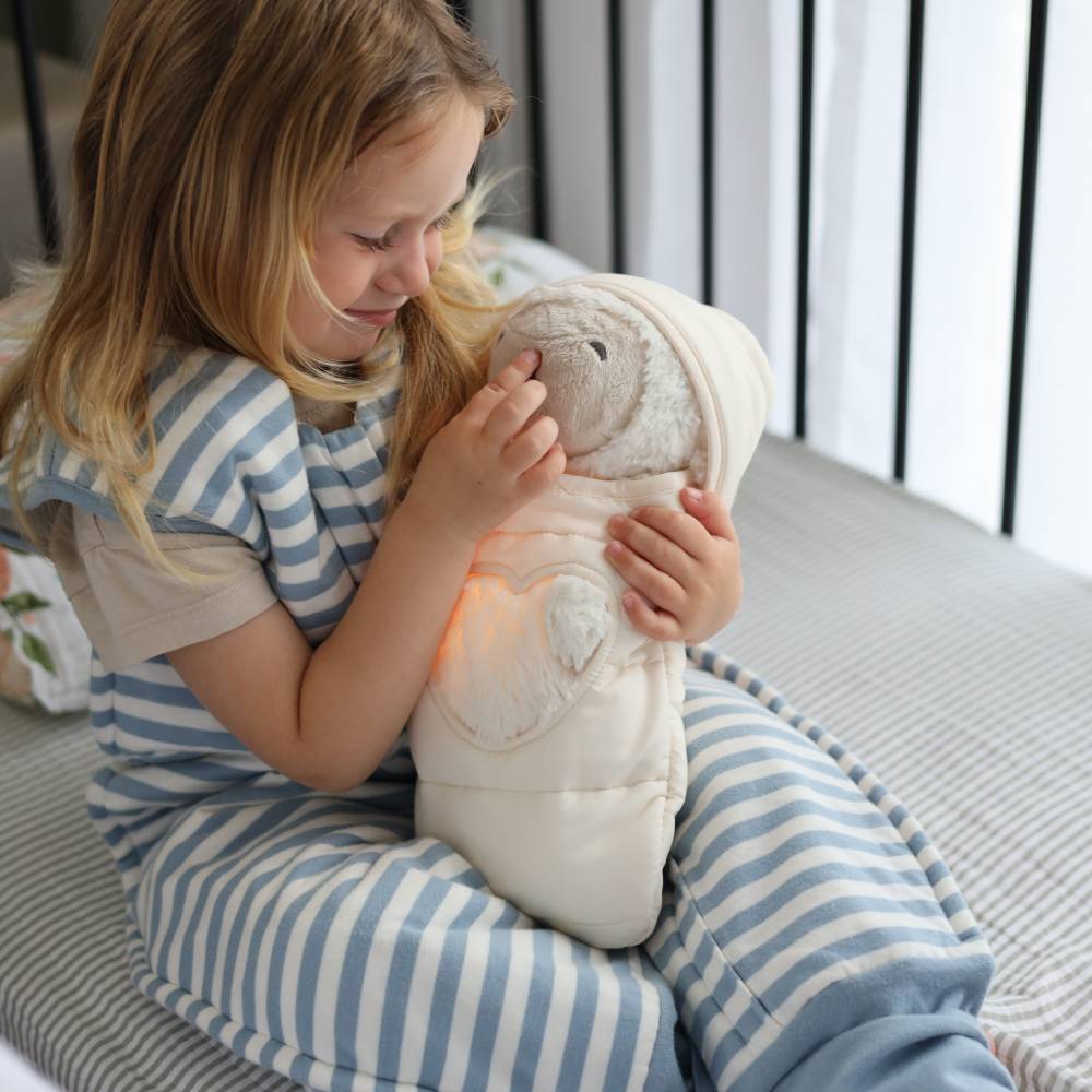 Child holding a plush toy in a cozy indoor setting