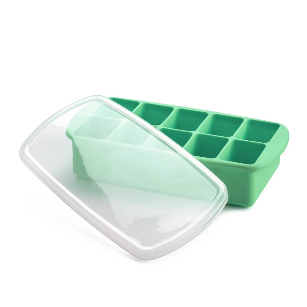 Green silicone baby food tray with a clear lid on a white background