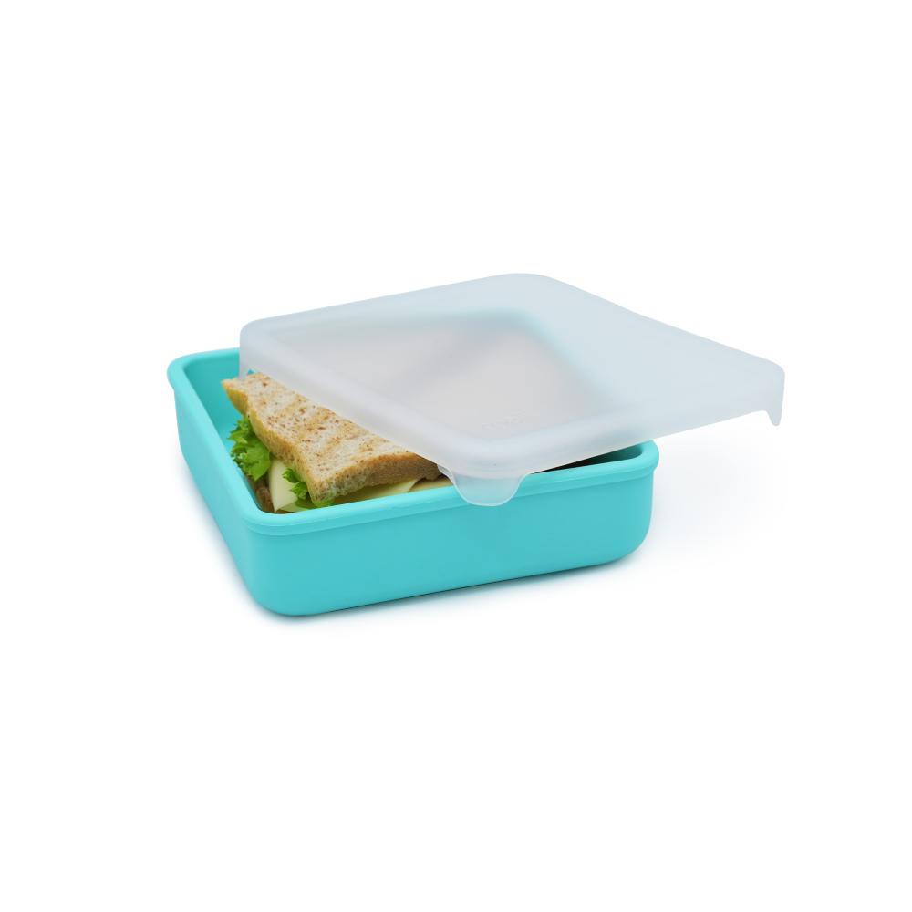 Turquoise lunch box with a sandwich and lettuce inside on a white background
