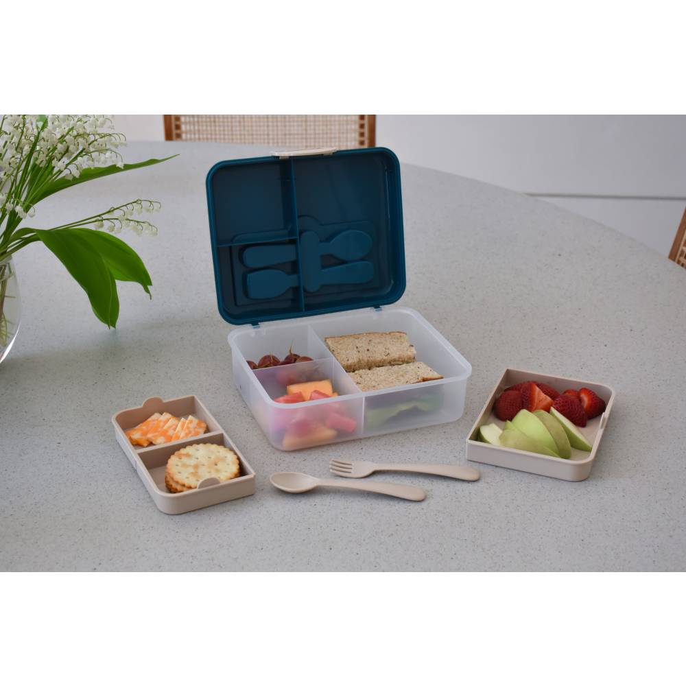 Bento box with compartments containing food items on a table.