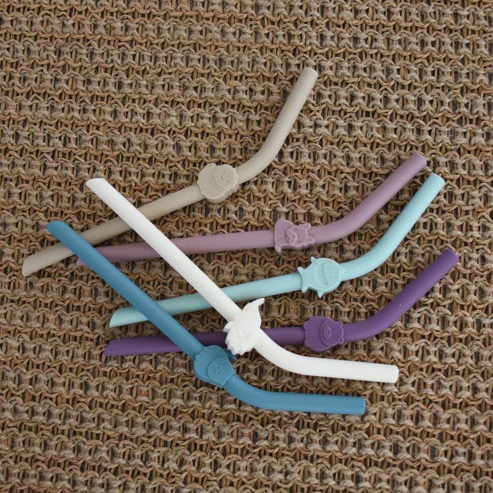 Set of colorful silicone straws on a textured brown background