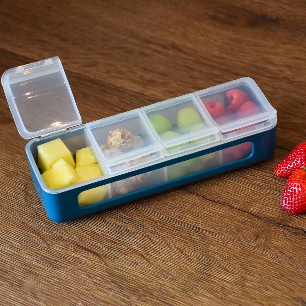 Blue and clear compartmentalized container with snacks on a wooden surface