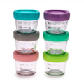 Set of 6 glass baby food containers with colorful lids stacked on a white background
