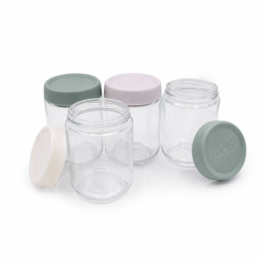 Set of clear glass overnight oat jars with colorful lids on a white background