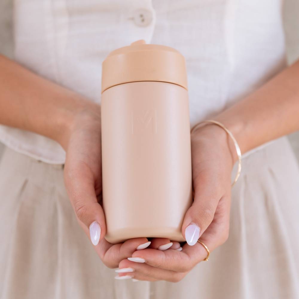 Hands holding a dune montii sipper bottle. 
