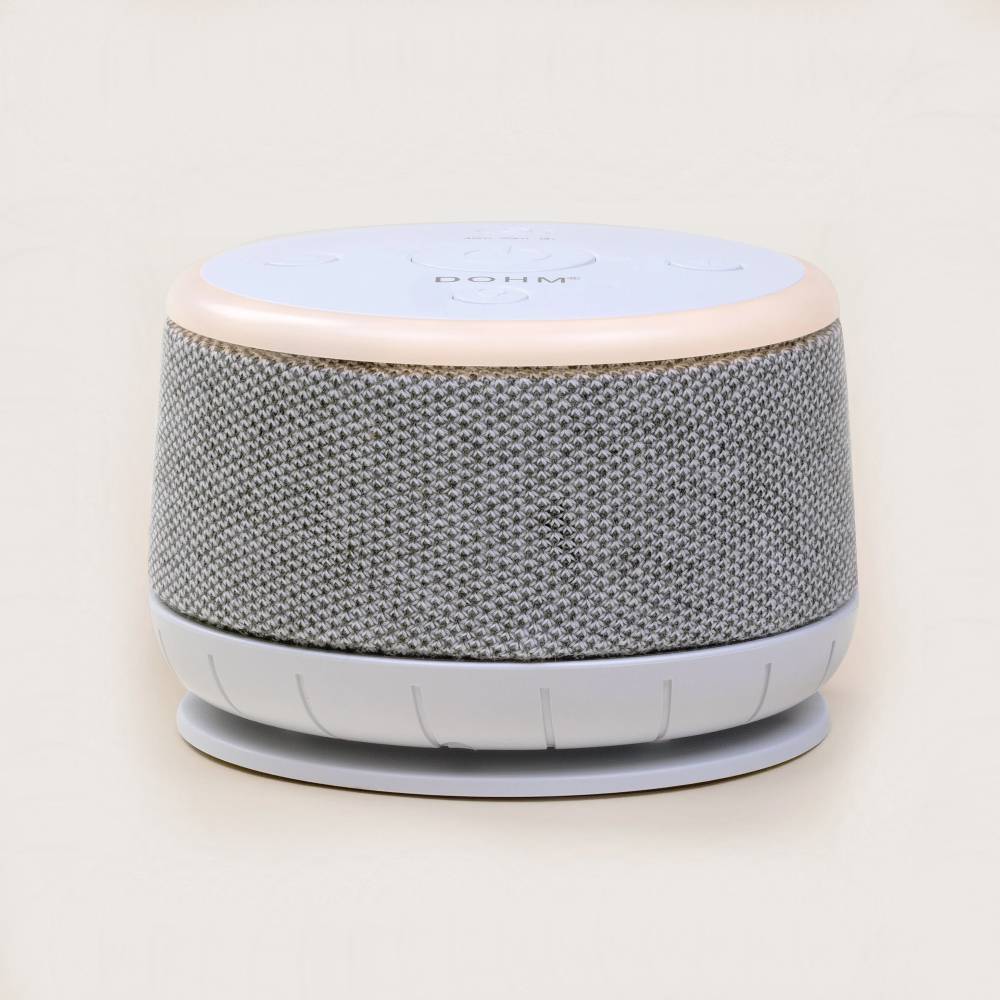 White noise machine with a light-colored top on a beige background