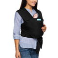 Mum carrying baby in black Moby baby carrier against white background.