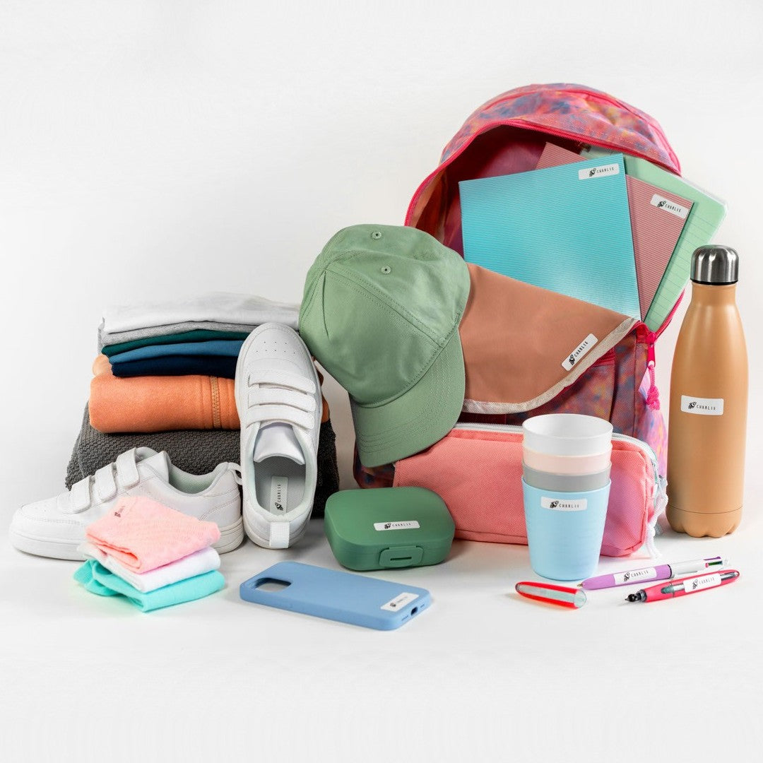 Backpack with colorful items including a cap, shoes, and stationery on a white background