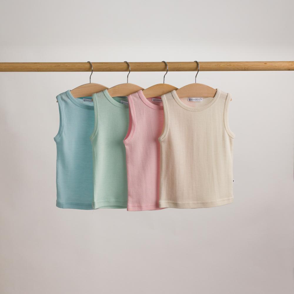 Four deluxe merino rib in pastel colors hanging on a rack against a plain background