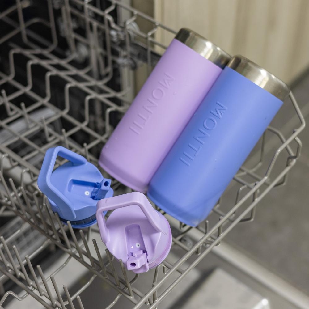 Purple and blue insulated bottles with caps inside a dishwasher.