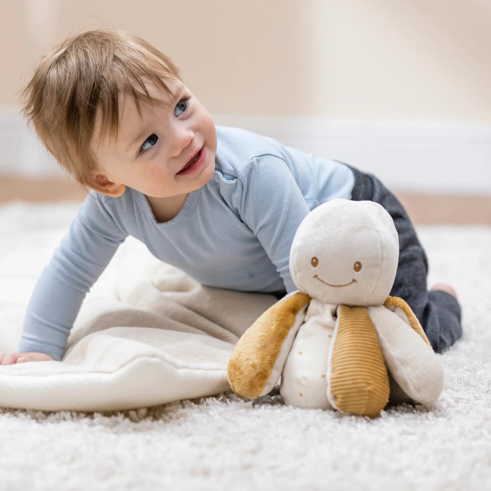 Child playing with a plush Octopus toy on a carpeted floor