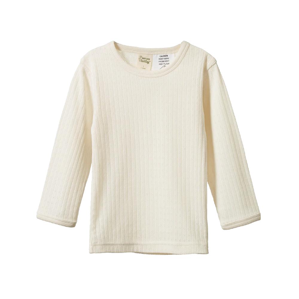 Cream-colored pointelle long-sleeve pyjama shirt on a white background