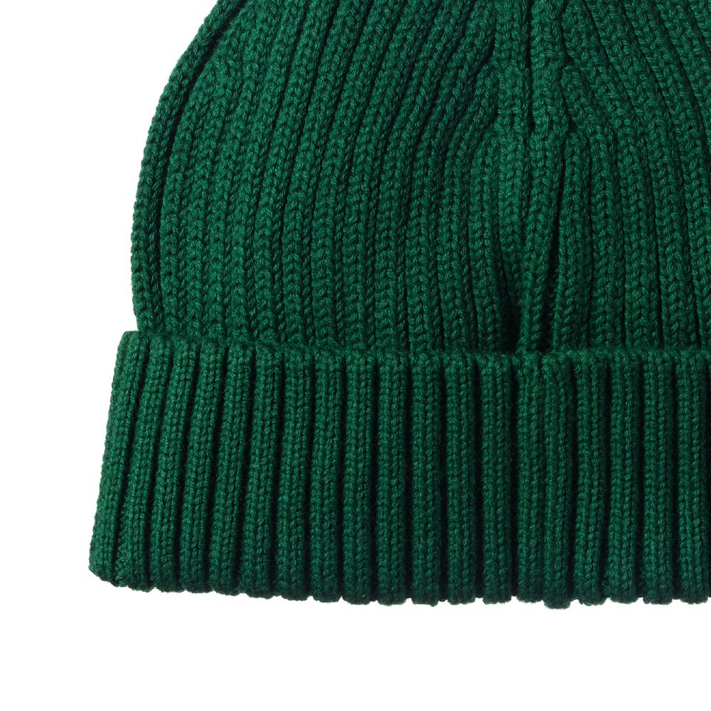 Close-up of a green chunky knit beanie on a white background
