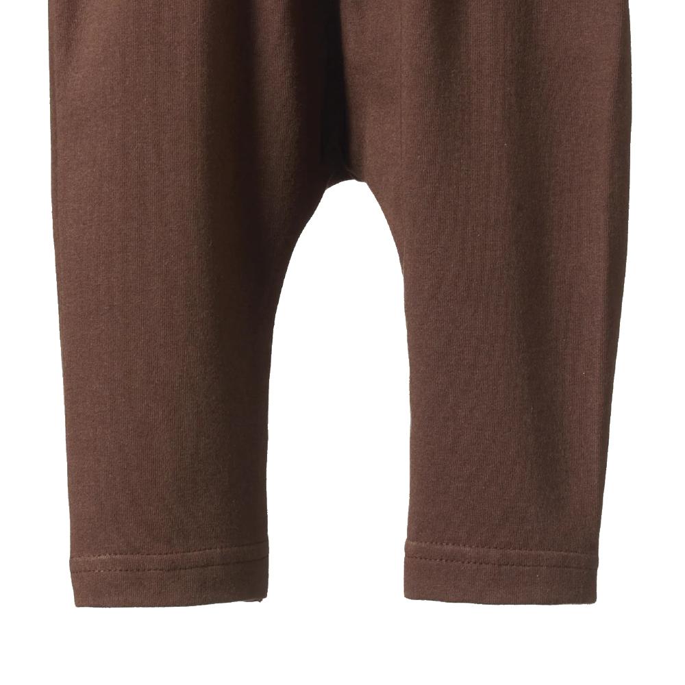 Close-up of brown pant legs on a white background