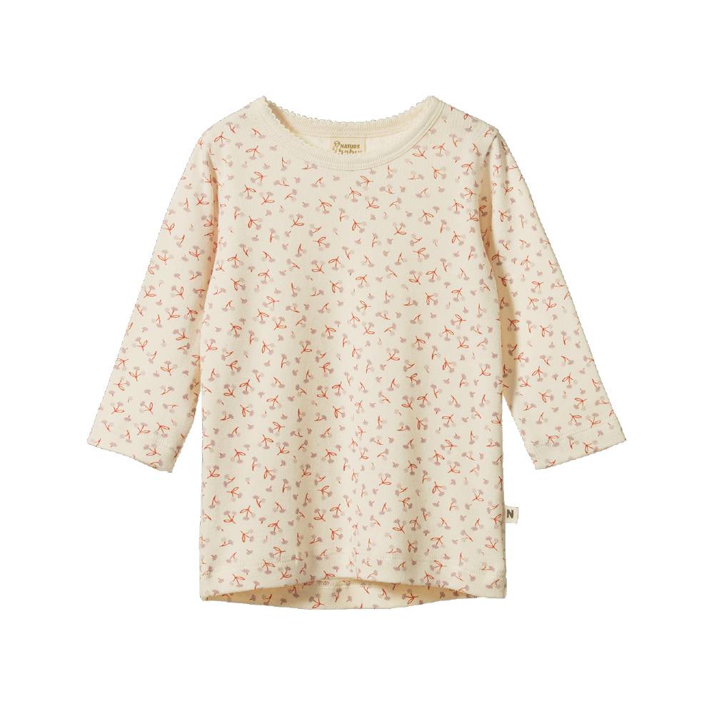 A cotton cream-colored long-sleeve top with a small, all-over pink floral pattern, shown flat against a plain white background.