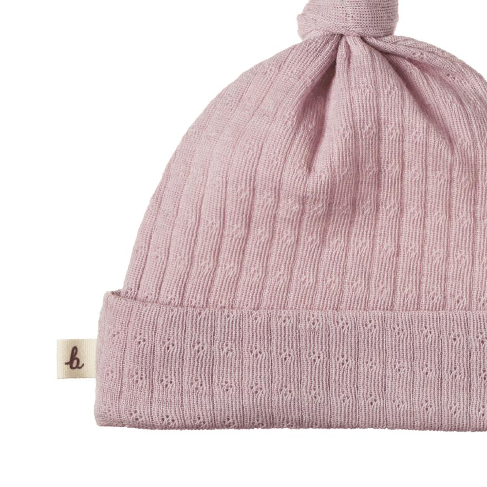 Lilac merino wool pointelle knit baby hat with a knot on a white background