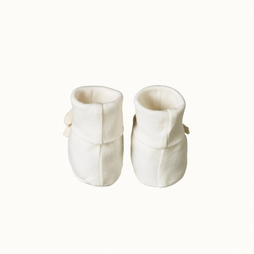 Pair of organic cotton white baby booties with cuff on a white background