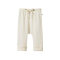Cream merino wool pointelle baby pants with a drawstring and cuffs on a white background