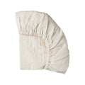 Cream organic cotton muslin fitted sheet on a white background