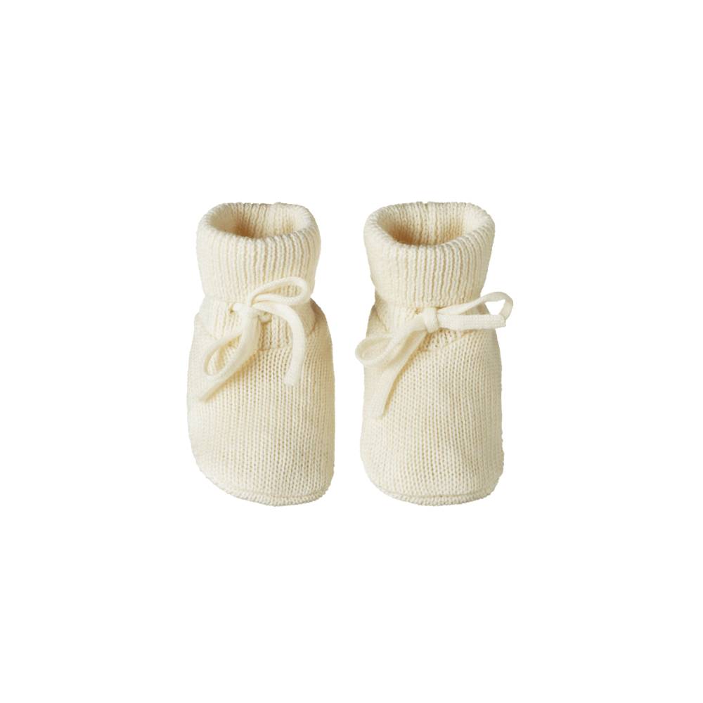 Pair of cream-colored merino knitted baby booties from Nature Baby on a white background